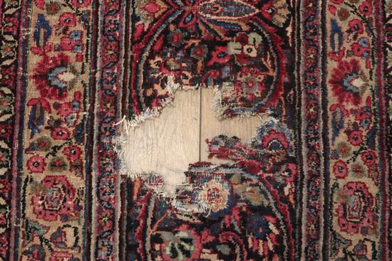 A Tabriz carpet with foliate pattern on a wine field (worn) approx. 480 x 340cm (holed)